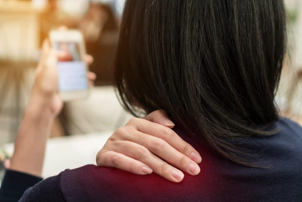 woman lifestyle shoulder pain. using smartphone too long.