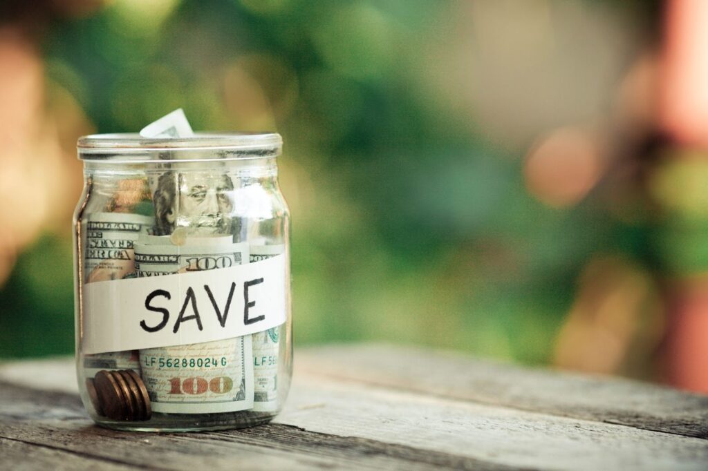 Glass jars with money and the label saying “save”