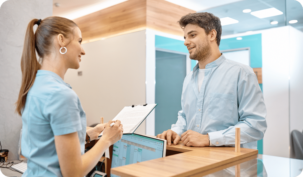 physical therapist talking to a patient at the front desk