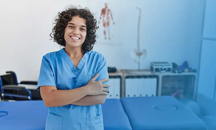 physical therapist stands against a bench in her clinic