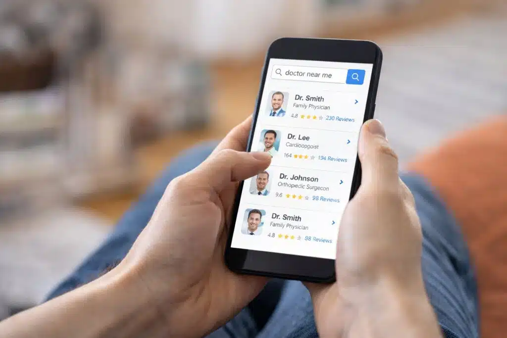 Person searching for doctors and reading reviews on a smartphone.