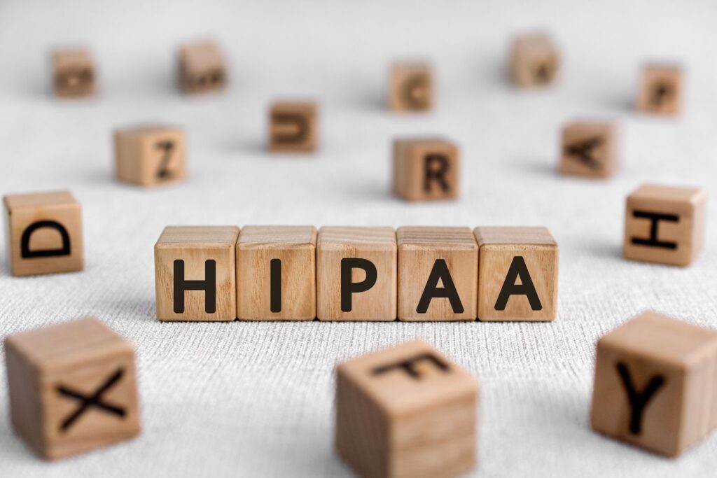 A row of five wooden toy blocks spelling out the word "HIPAA" in bold black letters.