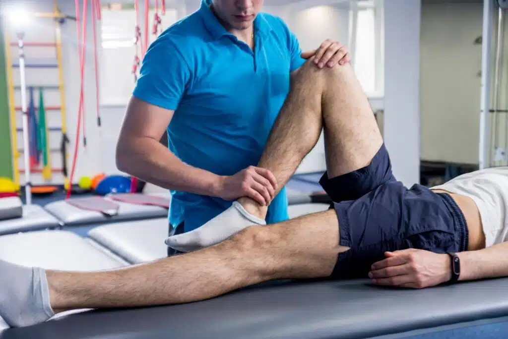 A physical therapist guiding a patient through a leg mobility exercise