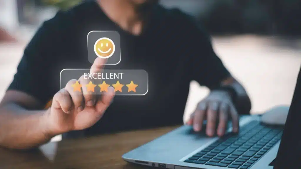 A person using a laptop and touching a glowing digital interface that displays a five-star rating