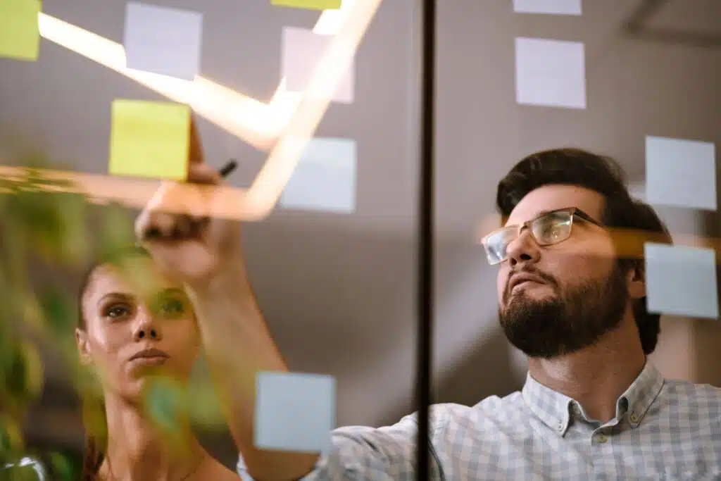 Team members discussing Leaking Buckets on sticky notes during a brainstorming session.